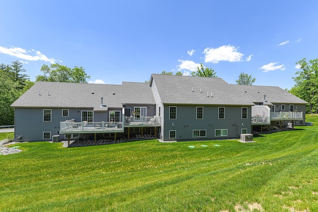 rear view of house featuring central AC unit, a wooden deck, and a lawn