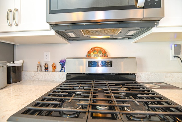 details featuring white cabinets and stainless steel appliances