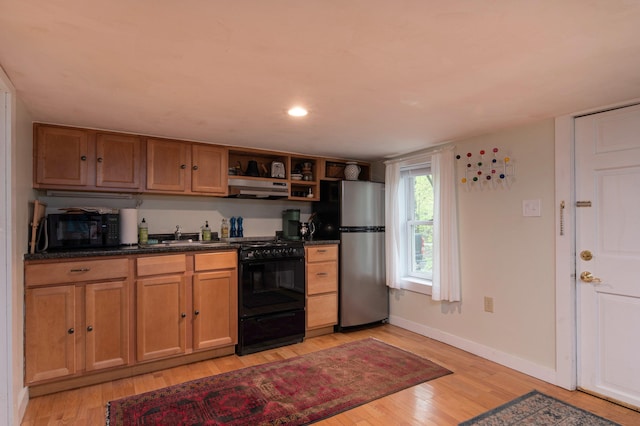 kitchen featuring sink, black appliances, extractor fan, and light hardwood / wood-style floors