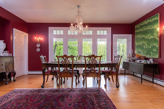 dining area with light hardwood / wood-style floors and a notable chandelier