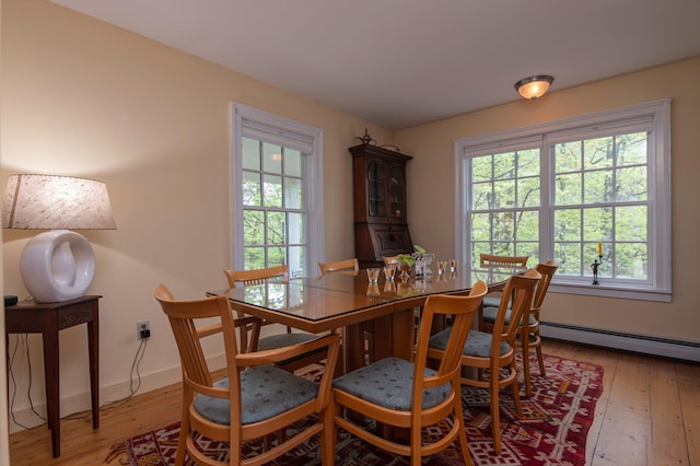 dining area with hardwood / wood-style floors and baseboard heating