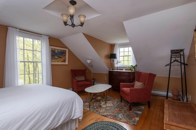 bedroom featuring a chandelier, lofted ceiling, a baseboard radiator, and light hardwood / wood-style flooring