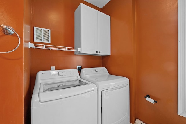 washroom featuring cabinets and independent washer and dryer