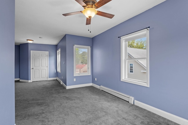 empty room featuring dark colored carpet, baseboard heating, and ceiling fan