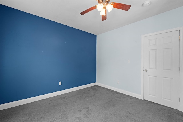 empty room featuring dark carpet and ceiling fan