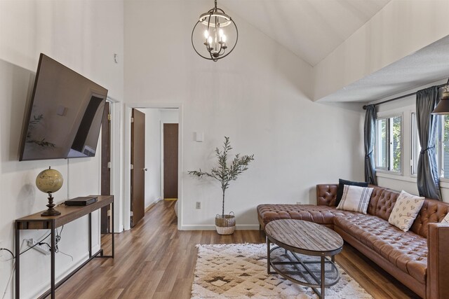 living room featuring a chandelier, wood-type flooring, and a high ceiling