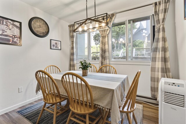 dining room featuring a chandelier, a baseboard radiator, and hardwood / wood-style floors