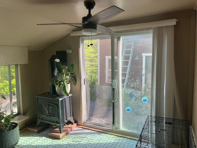 doorway featuring a wood stove and ceiling fan