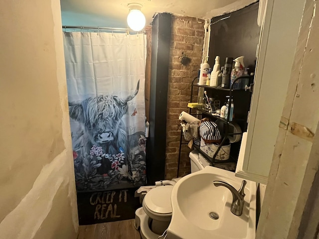 bathroom featuring a shower with shower curtain, hardwood / wood-style flooring, toilet, and sink