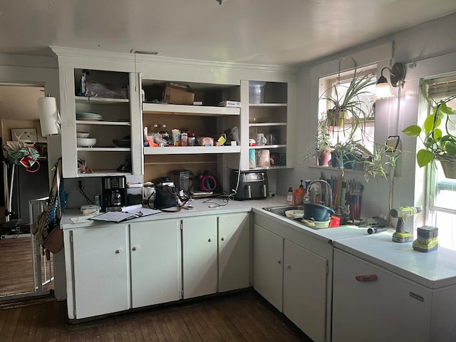 kitchen with dark hardwood / wood-style flooring, white fridge, white cabinetry, and sink