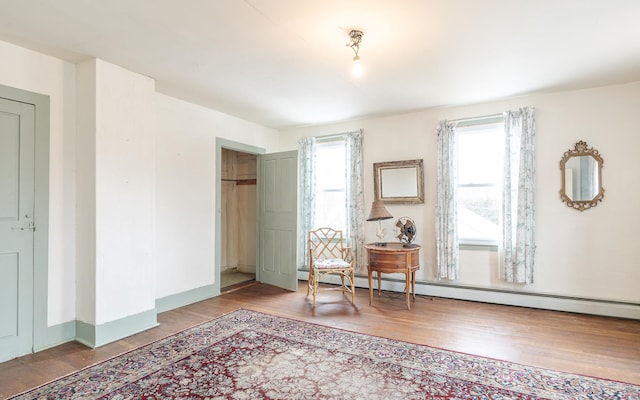 sitting room with baseboard heating and hardwood / wood-style floors