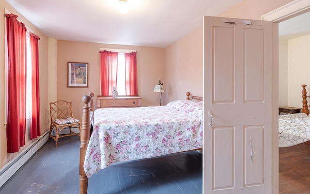 bedroom featuring dark wood-type flooring and a baseboard heating unit