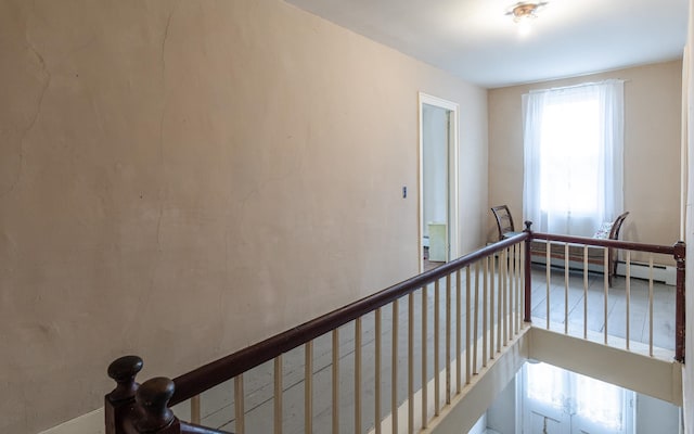 staircase featuring a baseboard heating unit