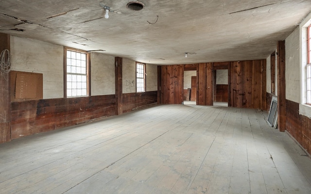 misc room featuring wooden walls and light hardwood / wood-style flooring