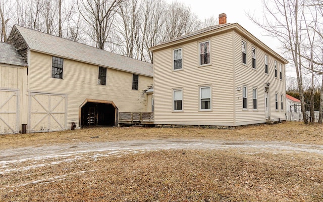 rear view of property featuring an outbuilding