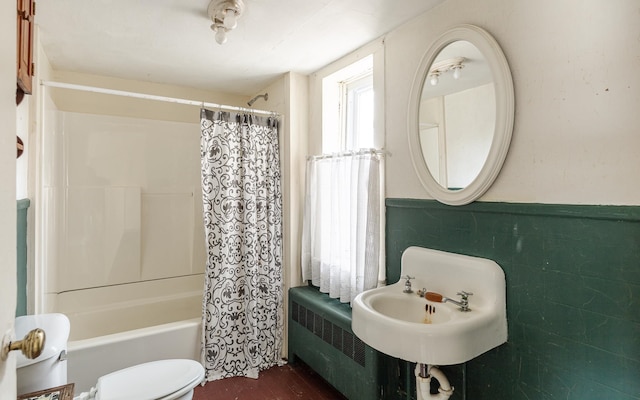 full bathroom with shower / tub combo, radiator, sink, tile walls, and toilet