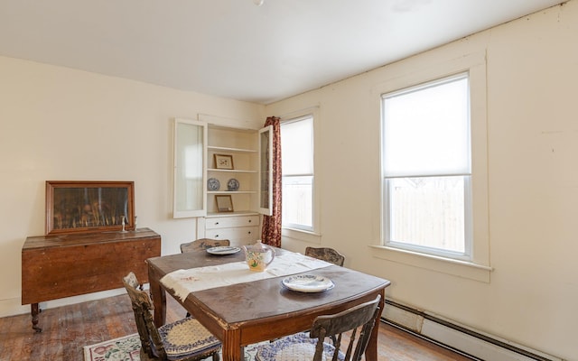 dining room with a baseboard radiator and wood-type flooring