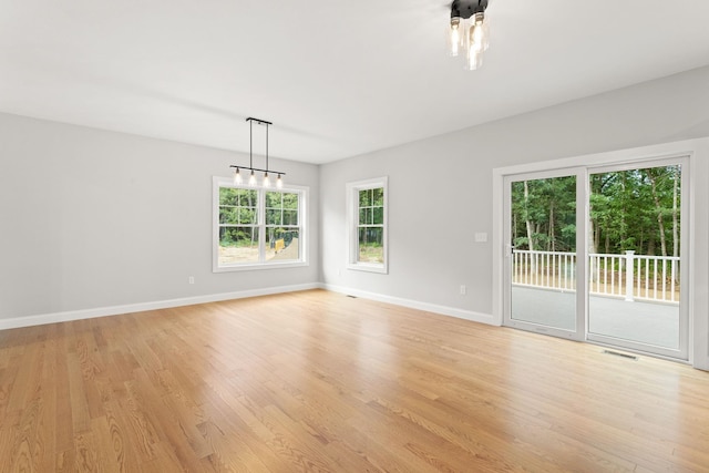 empty room featuring visible vents, baseboards, and light wood-style flooring