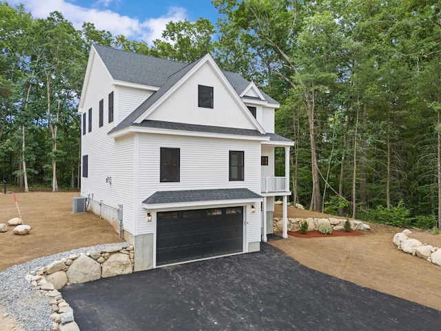 view of side of home featuring central AC, a balcony, and a garage