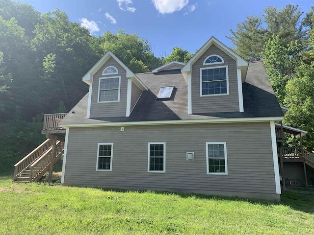 back of property featuring stairs, a deck, and a yard