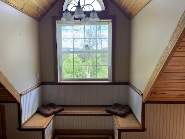 interior space featuring wainscoting, wooden ceiling, and an inviting chandelier