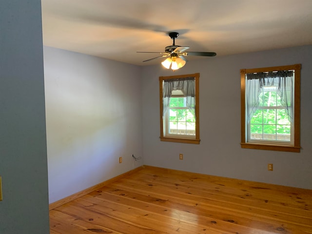 unfurnished room featuring ceiling fan, baseboards, and hardwood / wood-style floors