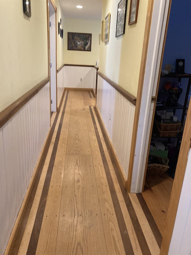 hallway with hardwood / wood-style flooring and wainscoting