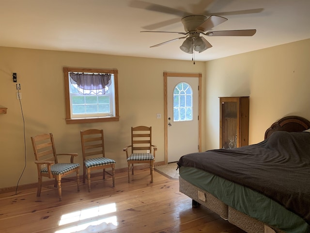 bedroom featuring baseboards, multiple windows, and hardwood / wood-style floors