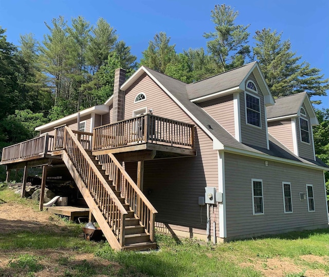 back of property featuring a wooden deck and stairs