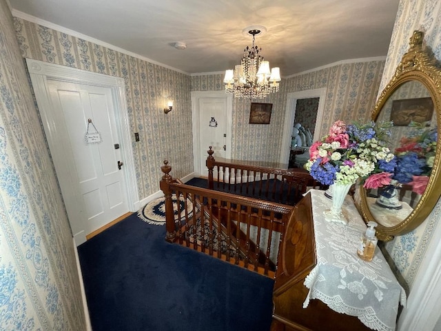 entryway with a chandelier, wallpapered walls, crown molding, and baseboards