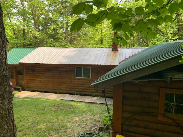 view of home's exterior with a chimney and metal roof
