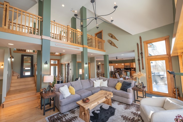 living room featuring a healthy amount of sunlight, a high ceiling, and light wood-type flooring