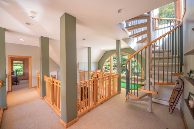 hallway with light colored carpet, baseboard heating, and lofted ceiling