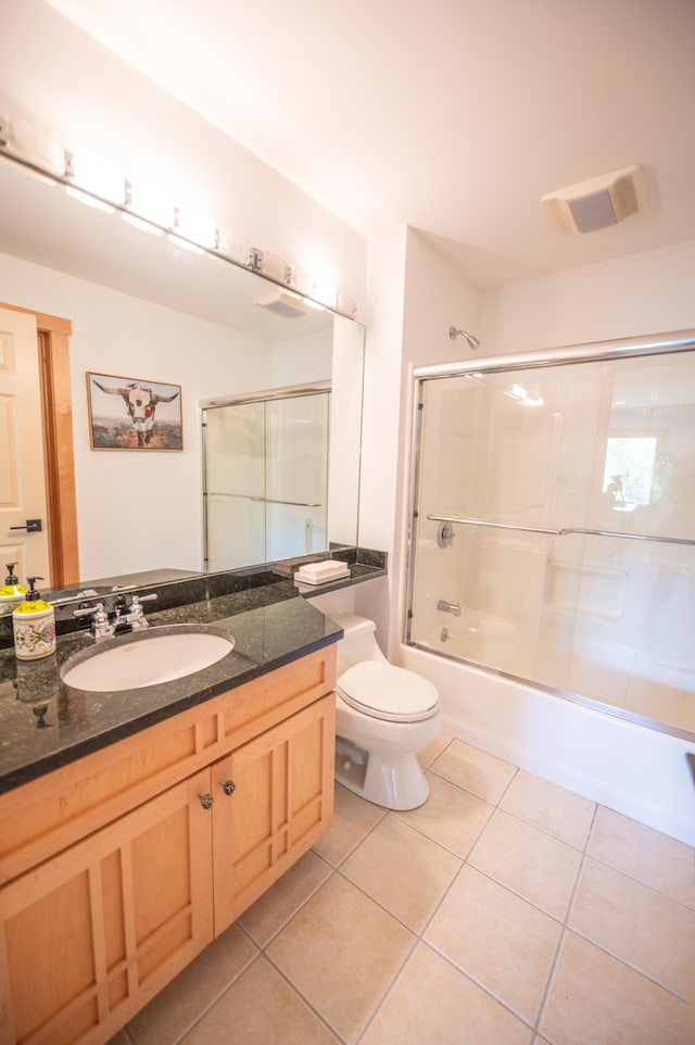 full bathroom featuring tile patterned flooring, vanity, enclosed tub / shower combo, and toilet