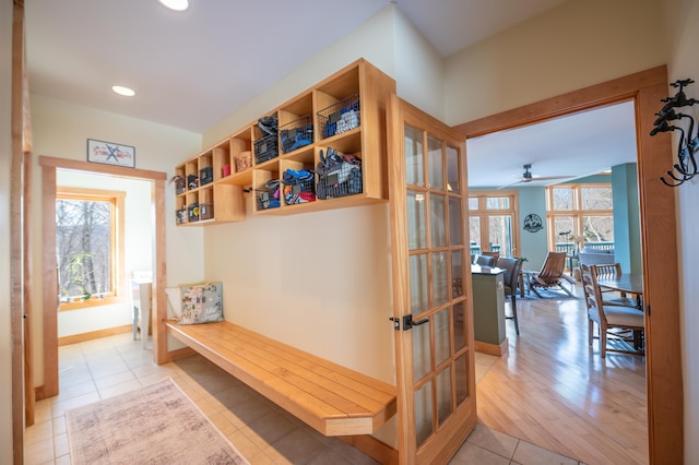 mudroom with ceiling fan, light tile patterned floors, and french doors