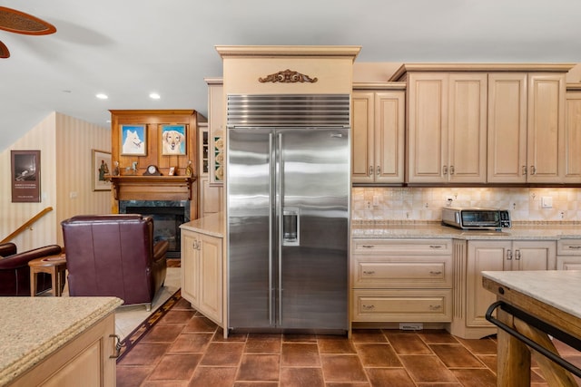 kitchen featuring stainless steel built in refrigerator, recessed lighting, a fireplace, a toaster, and decorative backsplash