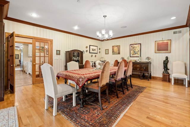 dining room with light wood-type flooring, visible vents, crown molding, and wallpapered walls