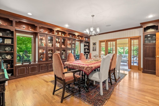 dining area with a notable chandelier, recessed lighting, light wood-type flooring, and crown molding