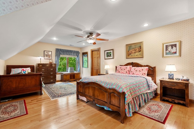 bedroom featuring wood finished floors, a ceiling fan, wallpapered walls, recessed lighting, and vaulted ceiling