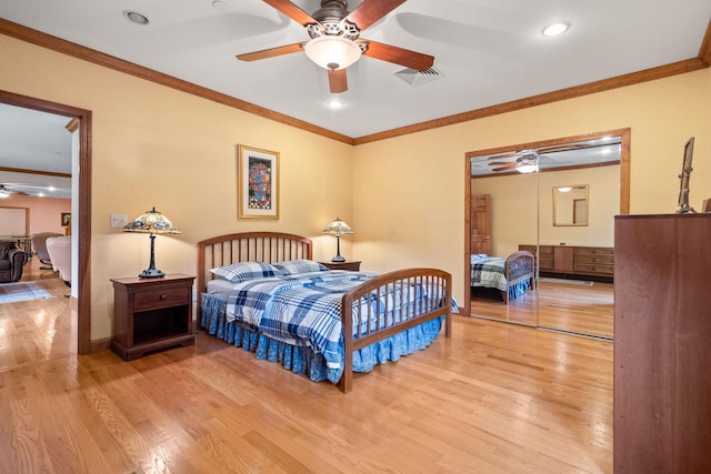 bedroom with visible vents, ornamental molding, wood finished floors, baseboards, and ceiling fan