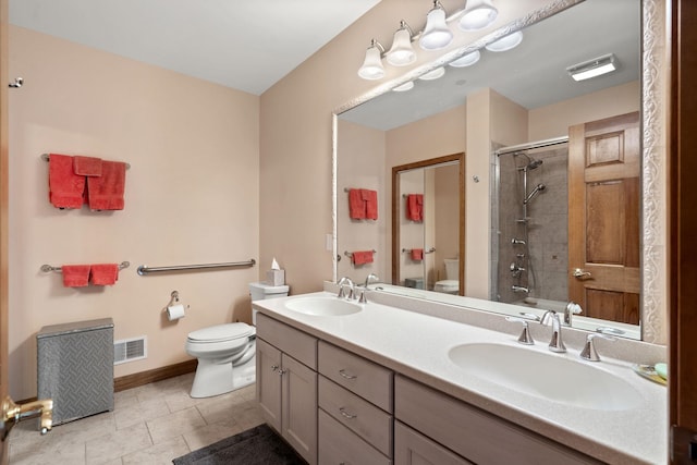 bathroom with a sink, visible vents, a shower with shower door, and toilet