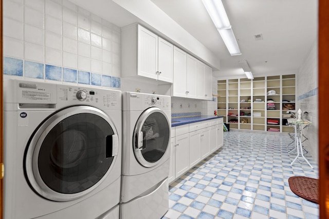 laundry room with separate washer and dryer, cabinet space, visible vents, and light floors