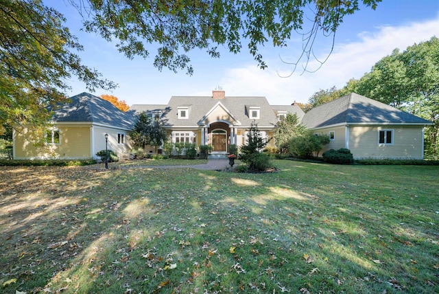 view of front facade with a front yard and a chimney