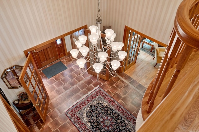 dining area with wallpapered walls and an inviting chandelier