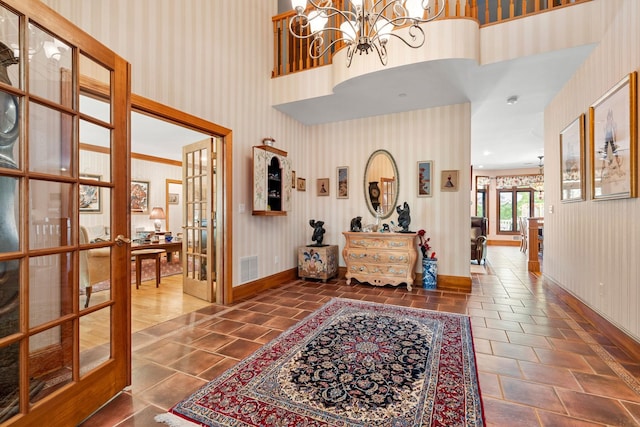 foyer featuring wallpapered walls, french doors, and visible vents