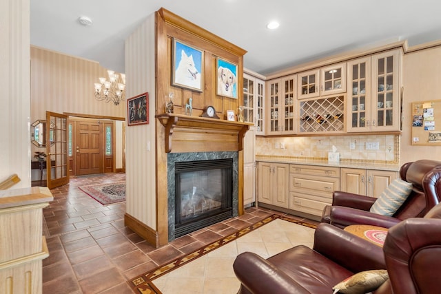 living room with a high end fireplace, baseboards, a dry bar, recessed lighting, and a notable chandelier