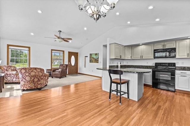 kitchen with a breakfast bar, black appliances, ceiling fan with notable chandelier, hanging light fixtures, and light hardwood / wood-style flooring