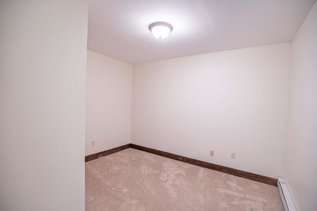 spare room with baseboard heating and light colored carpet