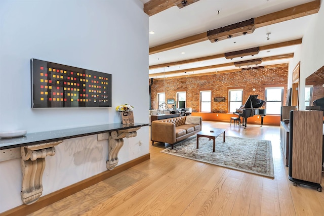 living room with beam ceiling, light wood-type flooring, and brick wall