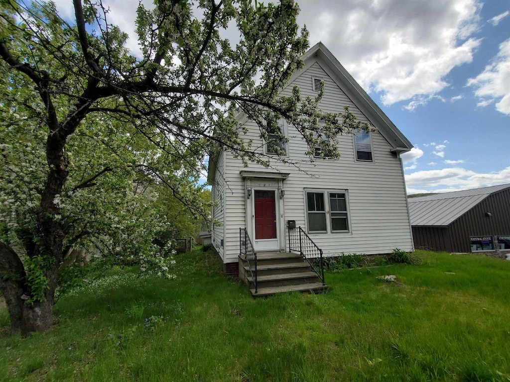 rear view of property featuring a lawn